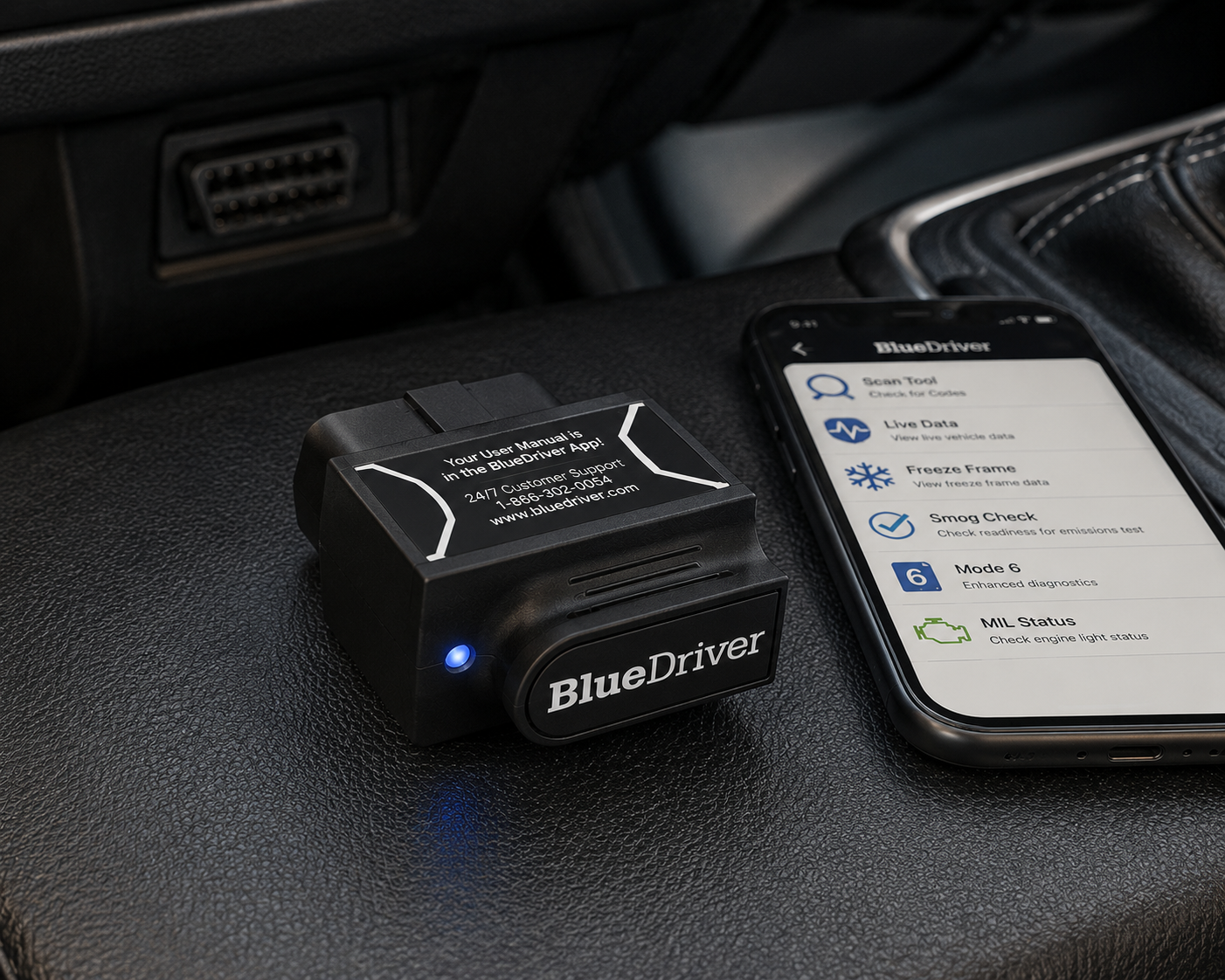 BlueDriver Bluetooth OBD2 scan tool plugged into a vehicle's OBD-II port next to a phone running the BlueDriver app