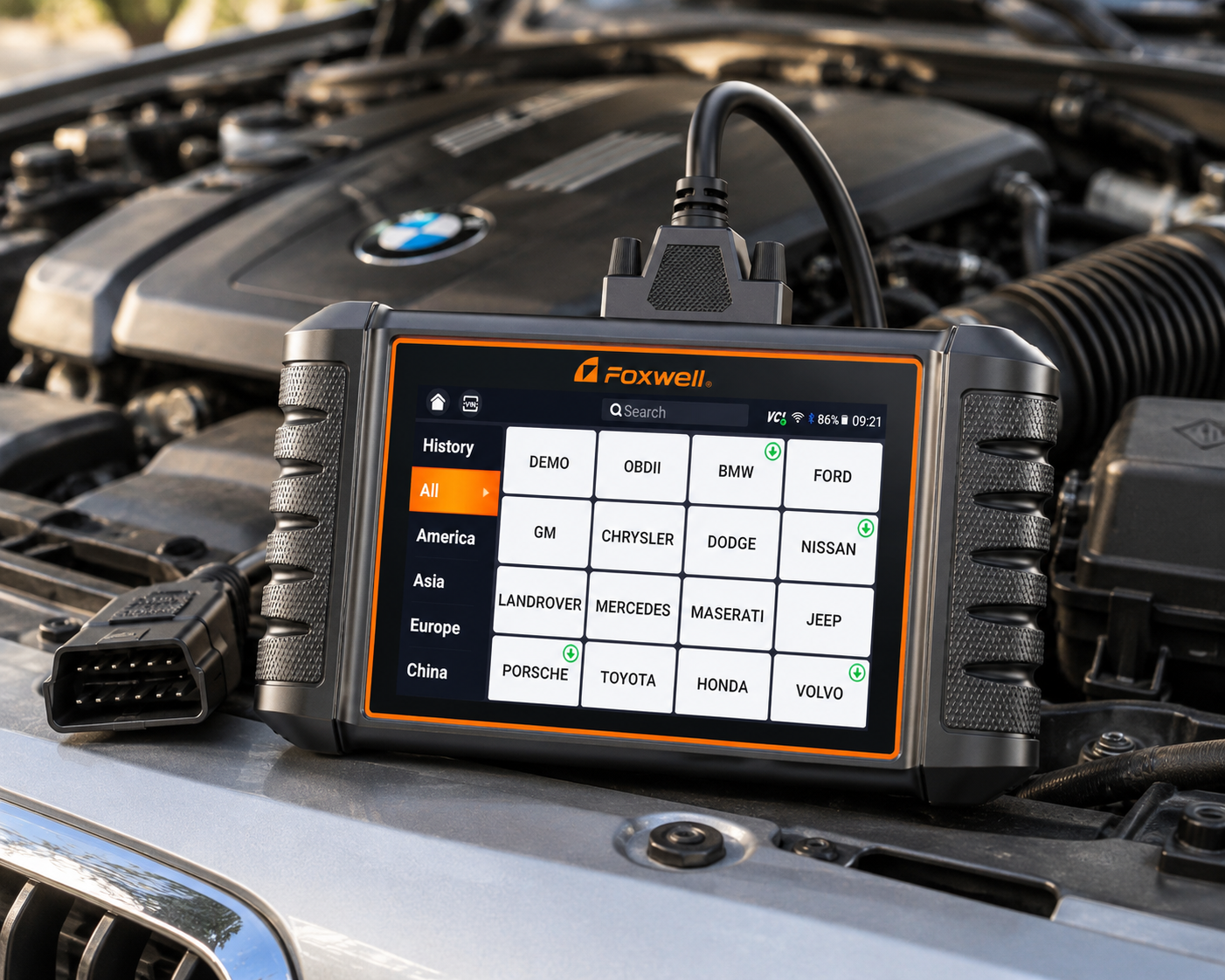 Foxwell NT716 bidirectional OBD2 diagnostic scanner in the engine bay of a silver sedan