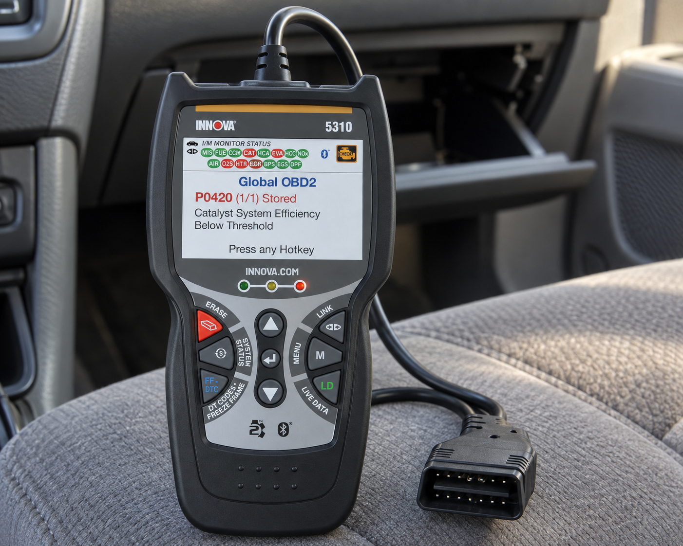 Innova 5310 OBD2 diagnostic scanner on the passenger seat inside a gray vehicle interior