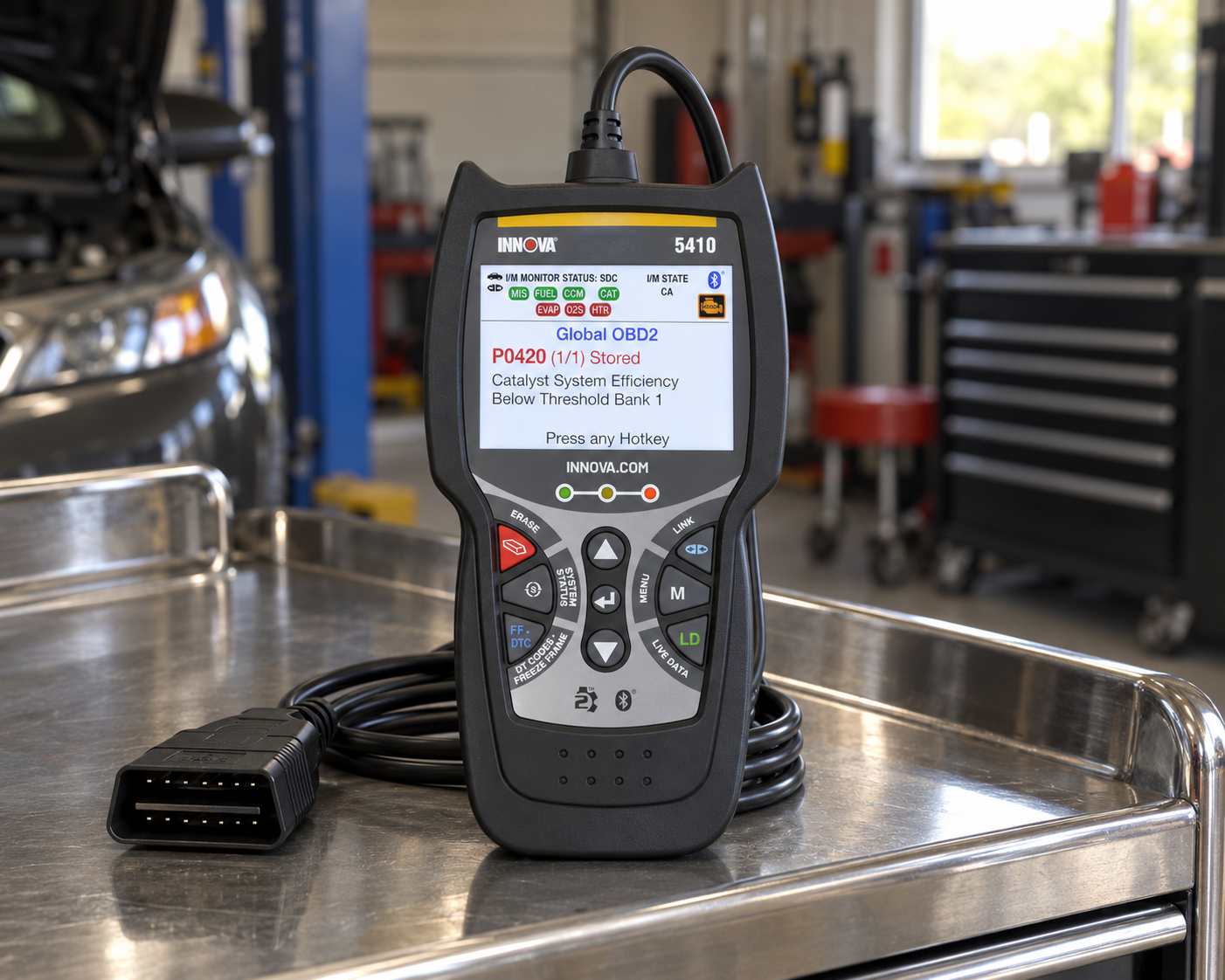 Innova 5410 OBD2 diagnostic scanner on a stainless steel mechanic tool cart in a workshop