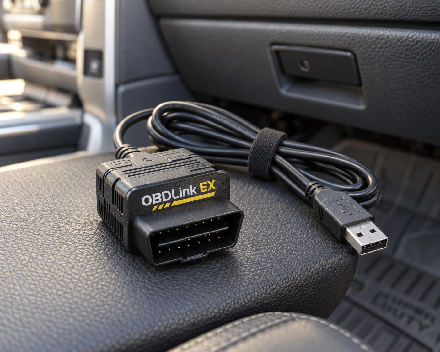 OBDLink EX FORScan OBD2 adapter with USB cable inside a Ford-style vehicle interior