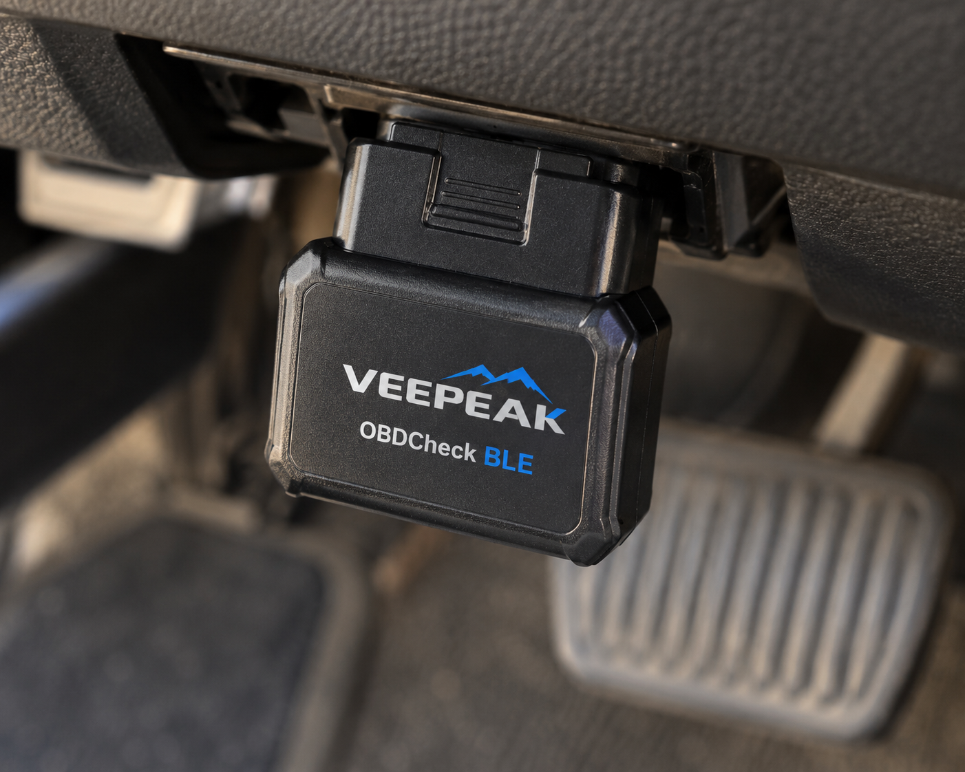 Veepeak OBDCheck BLE Bluetooth OBD2 adapter plugged into a vehicle diagnostic port beneath the dashboard